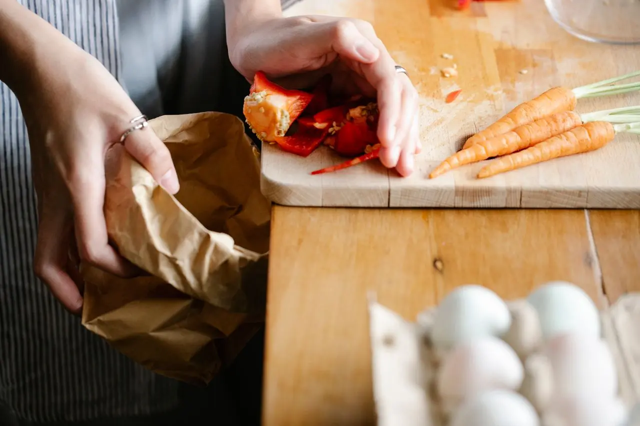 Kitchen scraps being added to a countertop compost bin
