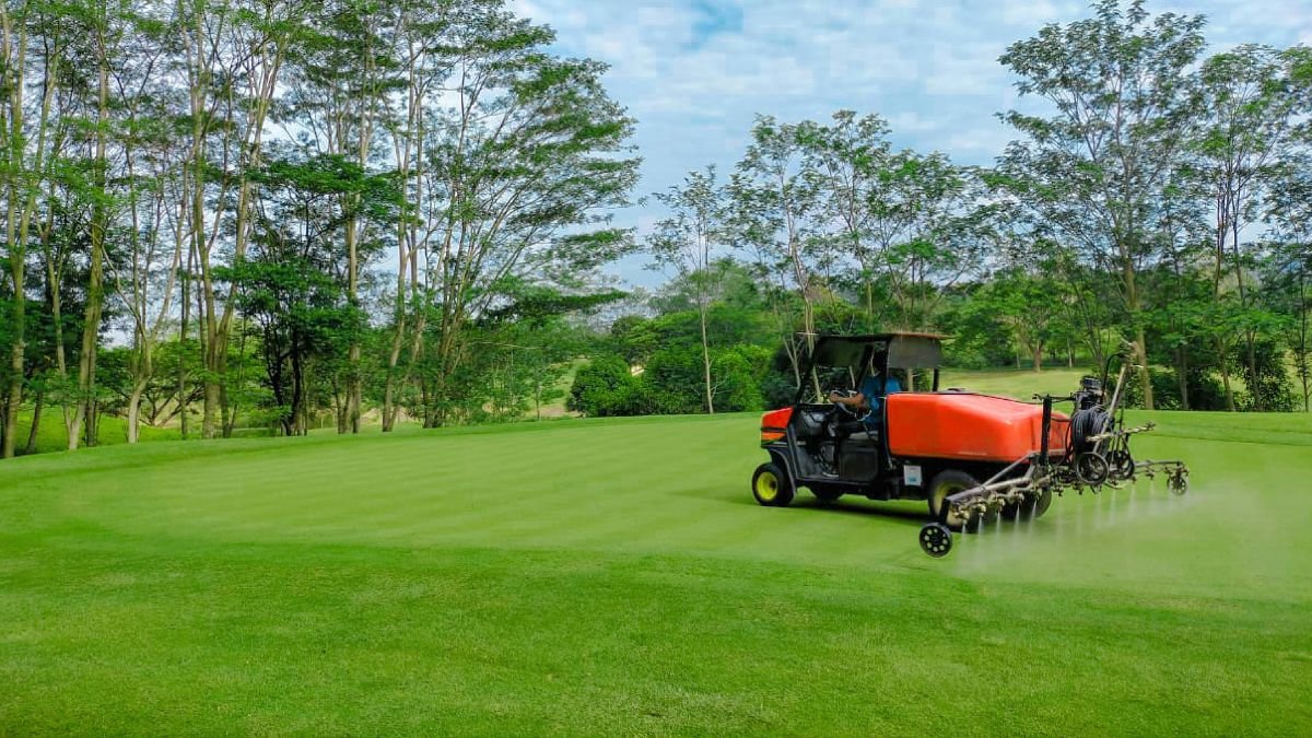 Spreader applying fertilizer on a lawn